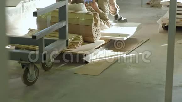 工人休息和使用电话在工作场所休息木质室内门的生产视频的预览图