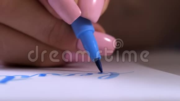书法家双手特写在白纸上写字美刻划装饰的字母书法视频的预览图