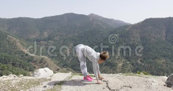 女性在岩石上伸展视频的预览图