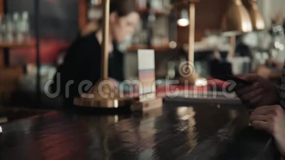 男人通过智能手机支付账单在咖啡馆里使用NFC技术喝柠檬水视频的预览图