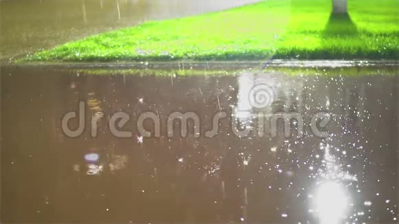 雨水溅落在城市的路面上夏天的暴风雨路面滑视频的预览图