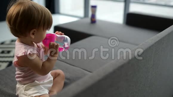 可爱的幼儿在沙发上喝水视频的预览图