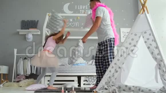 可爱的小女孩和她父亲抱着枕头打架视频的预览图