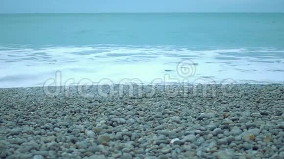 无尽的海洋在干净的鹅卵石海滩上的泡沫海浪自然保护视频的预览图