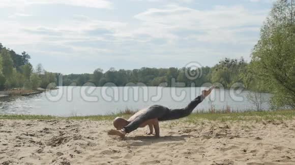 瑜伽士用手在沙子上保持平衡视频的预览图