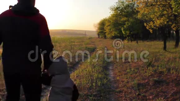 夏天日落时分快乐的爸爸和孩子在森林道路上奔跑视频的预览图