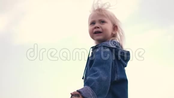 长发小女孩手里拿着沙子走向大海头发在风中飘扬视频的预览图