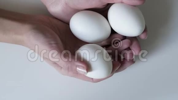 无法辨认的女人手里拿着三个鸡蛋复活节彩蛋复活节假期的概念手握鸡蛋视频的预览图