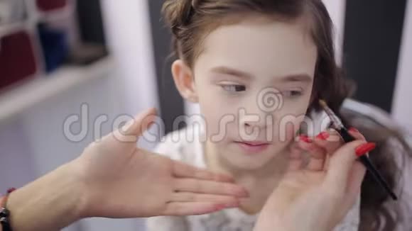 这个女孩是一个化妆大师她把嘴唇涂在一个模特儿上视频的预览图