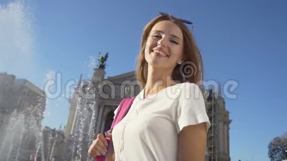 快乐的旅游女孩站在喷泉附近视频的预览图