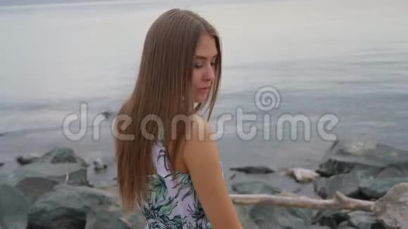 穿裙子的女孩站在岩石上视频的预览图