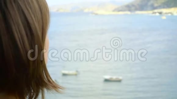 红发女孩站在酒店的阳台上望着泻湖视频的预览图