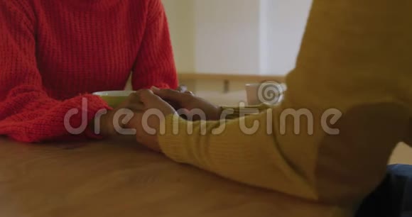 一对千禧夫妇手牵手坐在家里视频的预览图