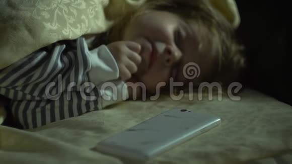 僵尸的手对一个熟睡的小女孩的电话很感兴趣视频的预览图