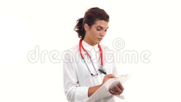 友好的年轻女医生在剪贴板上评论和写笔记青年医学专业人士画像视频的预览图