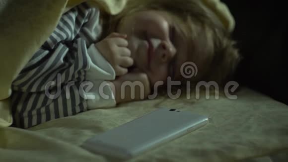 怪物的手对一个睡着的小女孩的手机感兴趣视频的预览图