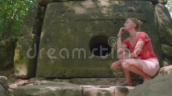 年轻的白种人女孩沉思地坐在古老的杜门前视频的预览图