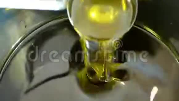 橄榄油有机品质生物从橄榄中获得的液体活性黄金混合和倒入钢桶中用于冷视频的预览图