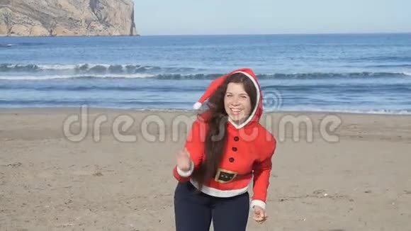 穿着圣诞帽跳舞和在海滩上玩得开心的漂亮年轻女子视频的预览图