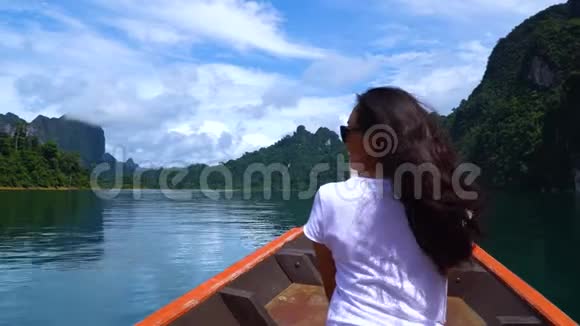 亚洲女孩在热带雨林中一个美丽的湖上乘船航行视频的预览图