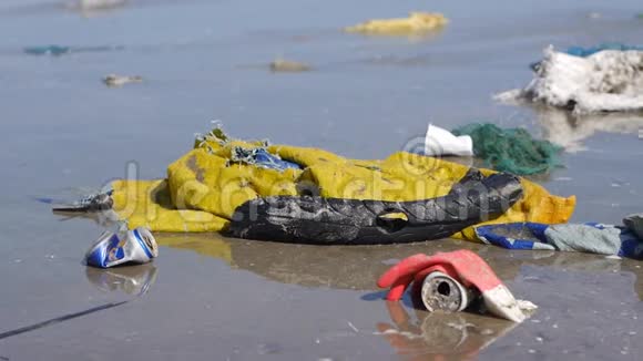 在海滩上的塑料垃圾和垃圾的近距离倾斜视频的预览图