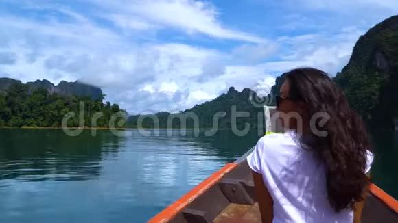 女孩在热带雨林中的一个美丽的湖上乘船航行视频的预览图