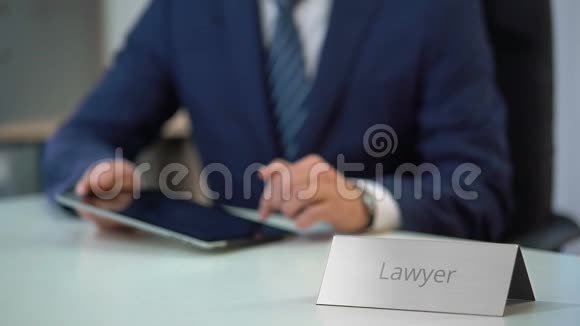 专业律师在平板电脑触摸屏上滑动文件处理案件视频的预览图
