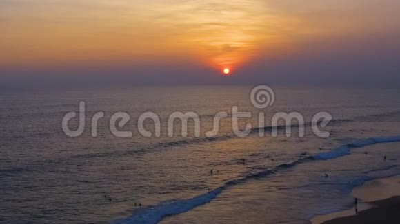 热带日落太阳落在海洋上海水在黄昏的灯光下波浪无人机在海滩上飞翔视频的预览图