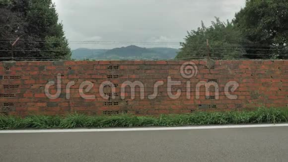 带山背景的道路上的红砖围栏视频的预览图