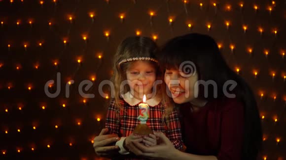 一个小女孩和她妈妈一起在节日蛋糕上吹蜡烛视频的预览图