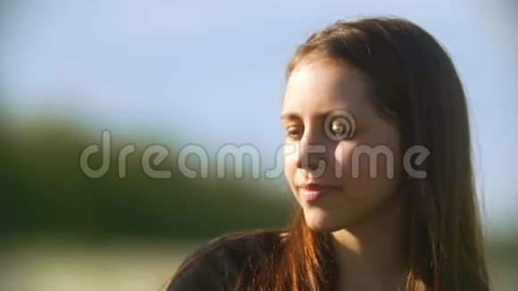 大自然中夏日吹蒲公英的年轻女子肖像视频的预览图