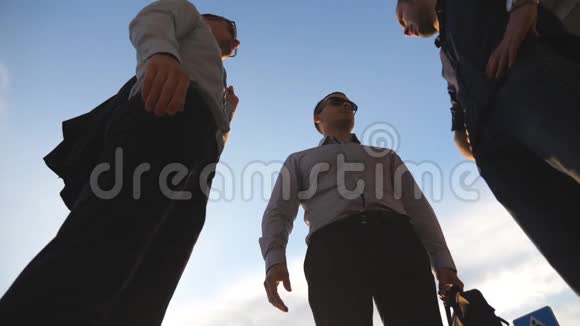三个商人站在户外聊天的低角度视角商人们在市外与视频的预览图