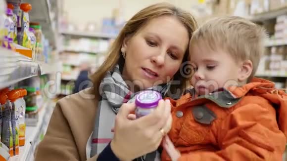 一位母亲带着孩子在商店里选择婴儿食品视频的预览图