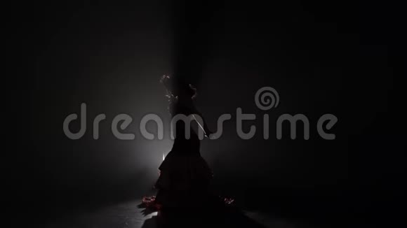 女人用她的手跳舞从后面的光烟雾背景慢动作剪影视频的预览图