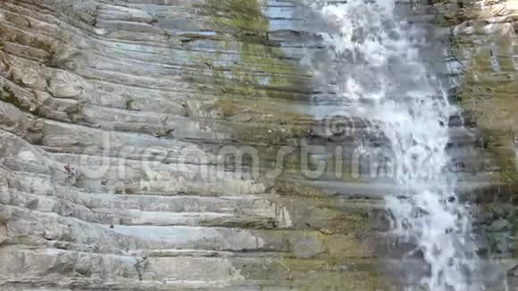 石壁上的小纯瀑布干净的水从旧岩石中掉下来视频的预览图
