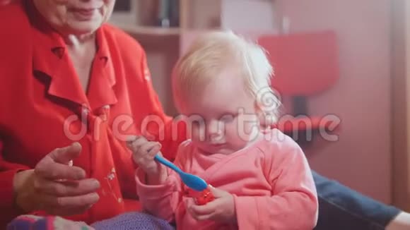 可爱的小女孩和她漂亮的祖母一起玩五颜六色的玩具视频的预览图