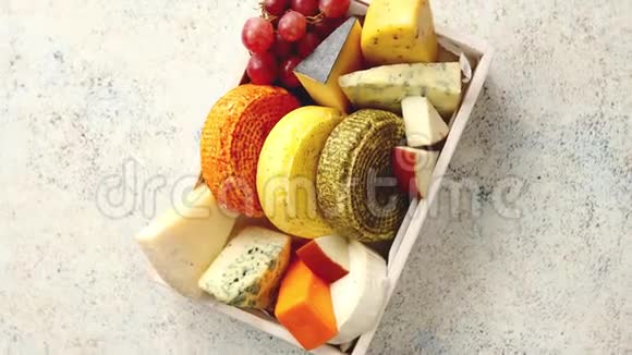 新鲜美味的不同种类的奶酪放在装有葡萄的木箱里视频的预览图