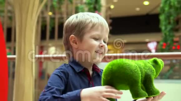 那个金发的小男孩在购物中心玩一个软玩具带着儿子的父亲考虑做生意视频的预览图