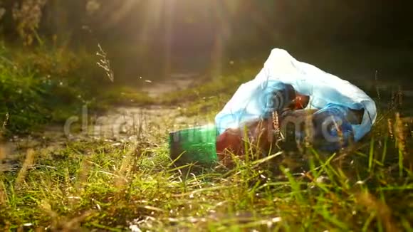 一包塑料垃圾在森林道路上污染了自然垃圾和自然阳光视频的预览图
