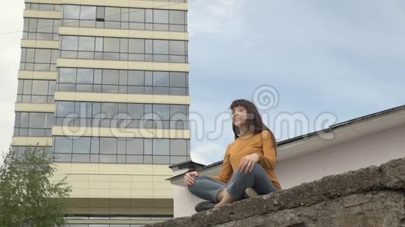 一个女人在屋顶上的莲花位置冥想视频的预览图