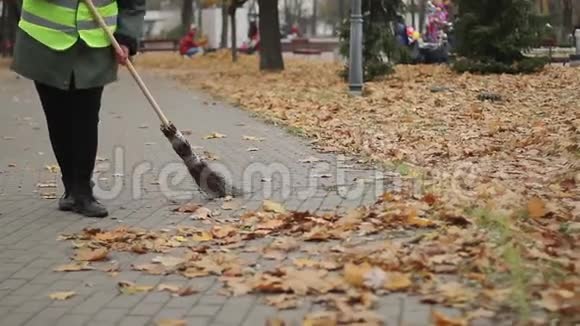 辛勤工作的清洁女工在公园户外清扫树叶低收入工作视频的预览图