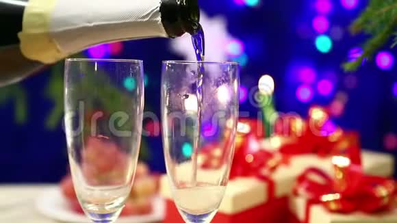 从瓶子里倒出两个杯子盛在桌上桌上放着新年礼物背景是h的灯光视频的预览图