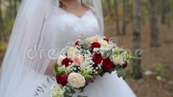 带着婚礼花束在森林里的新娘视频的预览图