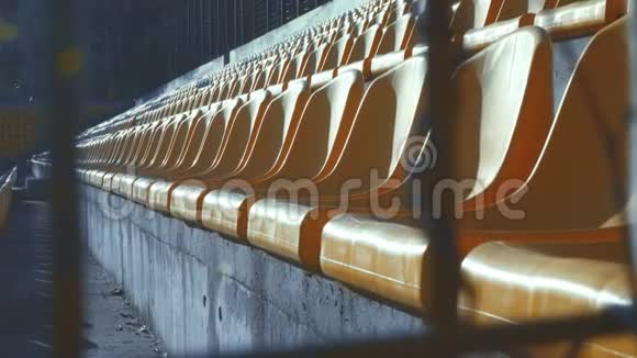 黄色椅子在一个金属栅栏后面的空体育场4k视频的预览图