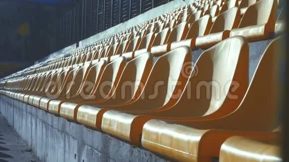 黄色椅子在一个金属栅栏后面的空体育场4k视频的预览图