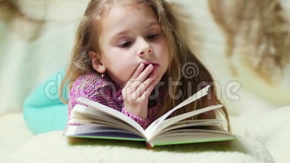 这个女孩在一种舒适的气氛中热情地读这本书视频的预览图
