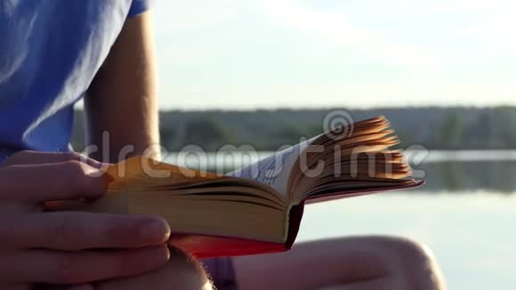 一个学生在斯洛莫的湖岸读一本小说视频的预览图