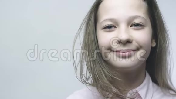 漂亮女孩的特写肖像脸上带着微微的微笑有着美丽眼睛的少女相机在移动视频的预览图