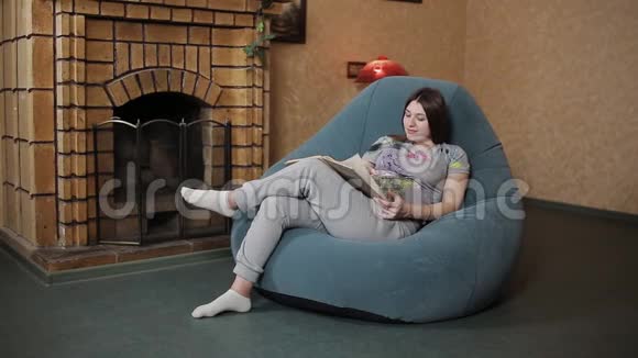 孕妇坐在沙发上看书视频的预览图