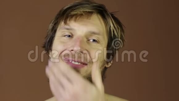 男人用电动剃须刀剪脸大胡子视频的预览图
